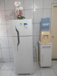 una nevera blanca en una habitación con un cubo de basura en Apartamento temporário Vila Yolanda, en Foz do Iguaçu