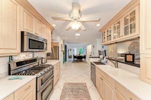 a large kitchen with a ceiling fan and appliances at The Cottage on Lido Key in Sarasota
