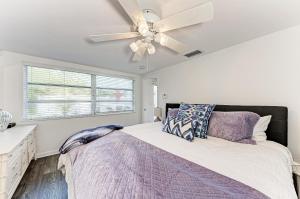 Schlafzimmer mit einem Bett und einem Deckenventilator in der Unterkunft The Cottage on Lido Key in Sarasota