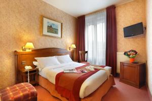 パリにあるホテル ペ レピュブリックの大きなベッドと窓が備わるホテルルームです。