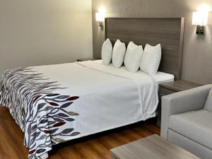 a hotel room with a bed and a chair at Red Roof Inn Greencastle South - Cloverdale in Cloverdale