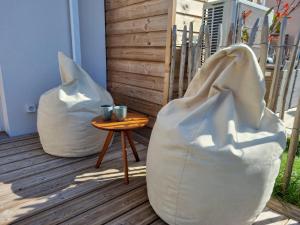 Dos grandes bolsas blancas junto a una mesa. en La Cabane de Jeanne ~ 10 minutes à pied de l'océan, en Mimizan