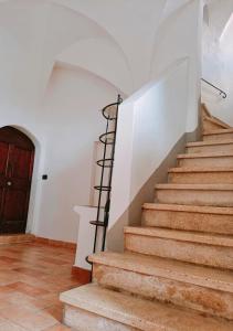 a staircase in a house with a wooden door at Vien mequé in Città di Castello