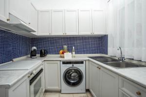 a kitchen with a washing machine and a sink at Salty Beach Front House Faliraki in Faliraki