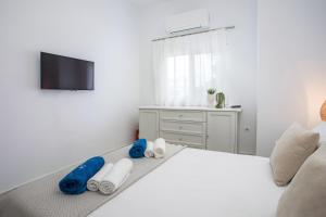 a bedroom with a white bed with towels on it at Salty Beach Front House Faliraki in Faliraki