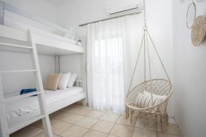 a swinging chair in a bedroom with a bunk bed at Salty Beach Front House Faliraki in Faliraki