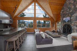 a large living room with a bar and some chairs at Pinnacle Ridge 34 - Ski In Ski Out, Private Hot Tub, Recently Renovated, Gas Fireplace in Whistler