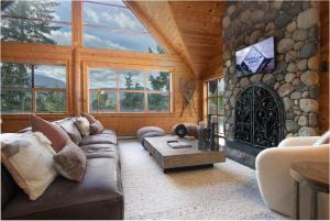 a living room with a couch and a stone wall at Pinnacle Ridge 34 - Ski In Ski Out, Private Hot Tub, Recently Renovated, Gas Fireplace in Whistler