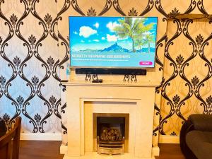 a fireplace with a tv on top of it at Inviting 3 -Bed House in Birmingham in Birmingham