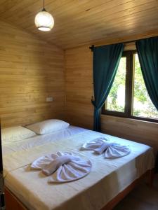 a bedroom with a bed with two towels on it at Anka Bungalov Hotel in Kemer