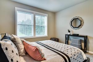 een slaapkamer met een bed met een spiegel en een raam bij Elegant Vancouver Townhome - 18 Mi to Portland in Battle Ground