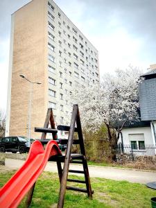 plac zabaw z czerwoną zjeżdżalnią i budynek w obiekcie Mieszkanie 2 pok 2 min do morza w mieście Sopot