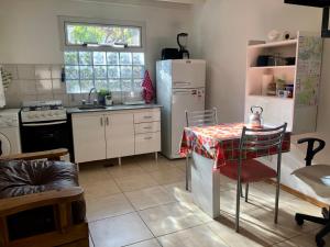 エスケルにあるQuilmeña al Sur departamento céntricoのテーブルと白い冷蔵庫のあるキッチン