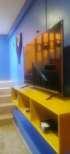 Un escritorio amarillo con un televisor encima. en Céntrico y Encantador Apartamento Angielin, en Valladolid