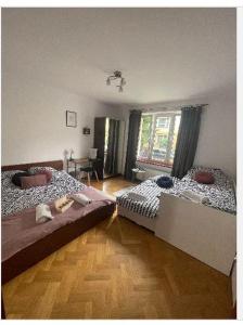 a bedroom with two beds and a wooden floor at Cheerful 3 bedroom city house in Krakow