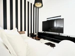 1 dormitorio con 1 cama blanca y TV en Ipanema Beach lovely apartment, en Río de Janeiro