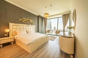 FIRST CLASS 3BR with full BURJ KHALIFA and FOUNTAIN VIEW في دبي: غرفة نوم بسرير كبير ومكتب وغرفة بها +37 صورة