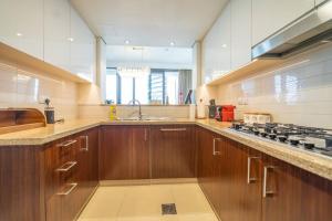 a large kitchen with wooden cabinets and a large window at FIRST CLASS 3BR with full BURJ KHALIFA and FOUNTAIN VIEW in Dubai