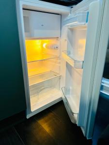 an open refrigerator with its door open and its at Luxury Suites near Wembley Stadium in London