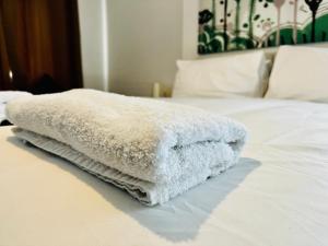 une pile de serviettes blanches assises au-dessus d'un lit dans l'établissement Luxury Suites near Wembley Stadium, à Londres
