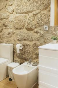 uma casa de banho com um lavatório e uma parede de pedra em Quinta do Rabelo em Braga
