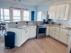 a kitchen with white cabinets and a counter top at Sunny Times in Holden Beach