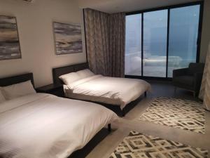 um quarto de hotel com duas camas e uma janela em Wadi Shab/Fins Villa em Fins
