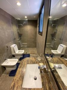 a bathroom with two toilets and a sink and a mirror at Wadi Shab/Fins Villa in Fins