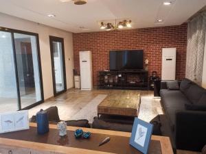 a living room with a couch and a flat screen tv at Wadi Shab/Fins Villa in Fins