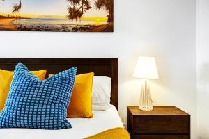 アレクサンドラ・ヘッドランドにあるBeach Life - Luxe beachfront Aptのベッドルーム1室(黄色と青の枕付きのベッド1台付)