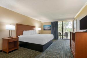 Best Western International Speedway Hotel في دايتونا بيتش: غرفه فندقيه بسرير وشرفه