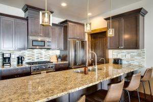 a kitchen with wooden cabinets and a granite counter top at Spacious Home with Mtn View Less Than 6 Mi to Park City! in Heber City
