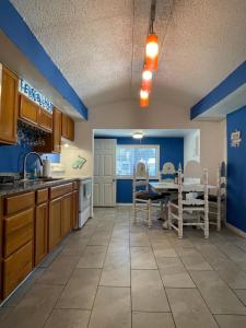 a kitchen with blue walls and a table and chairs at The Little Blue House - Pet Friendly! Fenced Backyard with Tiki Bar & Fire Pit in Hudson