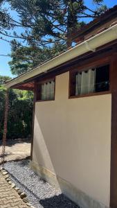 un edificio blanco con una ventana en el costado en POUSADA MAISON MAUÁ en Visconde De Maua