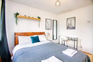 a bedroom with a large bed with a blue blanket at 2 Bed Camden Mews in London