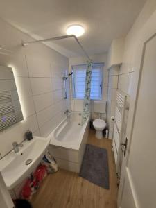 ein Badezimmer mit einer Badewanne, einem Waschbecken und einem WC in der Unterkunft Traumferienwohnung in Bad Friedrichshall in Bad Friedrichshall