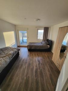1 Schlafzimmer mit 2 Betten und Holzboden in der Unterkunft Traumferienwohnung in Bad Friedrichshall in Bad Friedrichshall