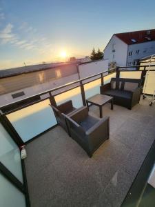 einen Balkon mit Stühlen und einem Tisch auf dem Dach in der Unterkunft Traumferienwohnung in Bad Friedrichshall in Bad Friedrichshall