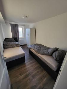 2 Betten in einem Zimmer mit Holzböden in der Unterkunft Traumferienwohnung in Bad Friedrichshall in Bad Friedrichshall