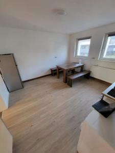 ein leeres Zimmer mit einem Tisch und zwei Fenstern in der Unterkunft Traumferienwohnung in Bad Friedrichshall in Bad Friedrichshall