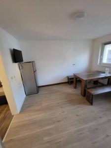 ein Wohnzimmer mit einem Tisch und einem Kühlschrank in der Unterkunft Traumferienwohnung in Bad Friedrichshall in Bad Friedrichshall