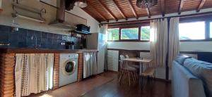 lavadero con lavadora y mesa en Buhardilla Ca'tio Celso, en San Esteban de la Sierra
