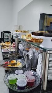 una línea de buffet con muchos platos de comida y repostería en Hotel Enlace, en Ji-Paraná