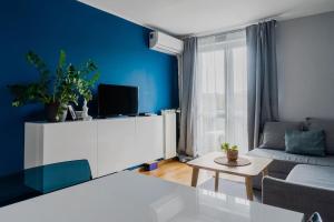 uma sala de estar azul com um sofá e uma mesa em Warsaw Concierge Kruczkowskiego em Varsóvia