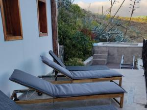 une paire de chaises longues assises sur une terrasse dans l'établissement CASA DEL MAQUINISTA, à Aguatona