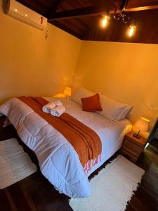 ein großes Bett in einem Zimmer mit zwei Lampen in der Unterkunft POUSADA MAISON MAUÁ in Visconde De Maua