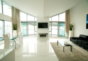 a white living room with a fireplace and a tv at Tory Hotel in Wellington