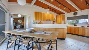 a large kitchen with a wooden table and chairs at 41 Collins Street Merimbula in Merimbula