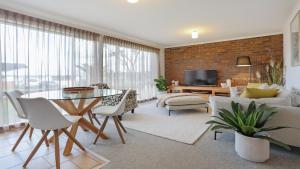 a living room with a table and a couch at 41 Collins Street Merimbula in Merimbula
