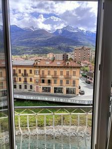 Appartamento in bassa montagna a Bussoleno في Bussoleno: منظر من نافذة مبنى به جبال